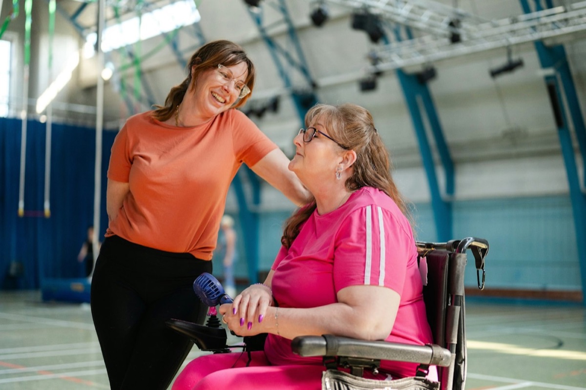 A support worker talking with a woman in a wheelchair
